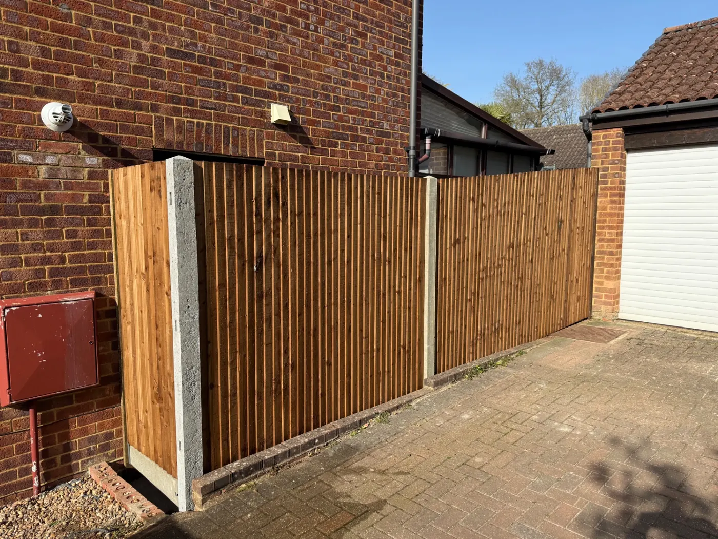 Closeboard fencing and driveway screening beside a garage
